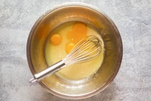 Key lime pie filling ingredients and a whisk in a mixing bowl.