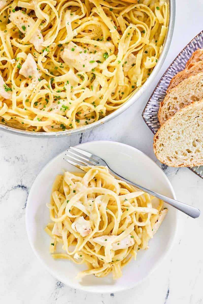 Overhead view of one pot chicken alfredo and slices of bread.