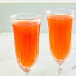 Strawberry mimosa in two champagne flutes.