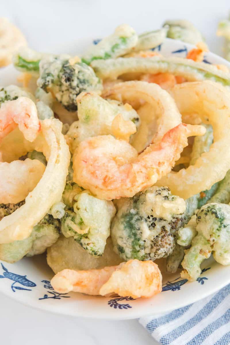 Homemade tempura batter fried shrimp and vegetables on a plate.