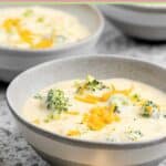 Three cheese broccoli soup in grey bowls.