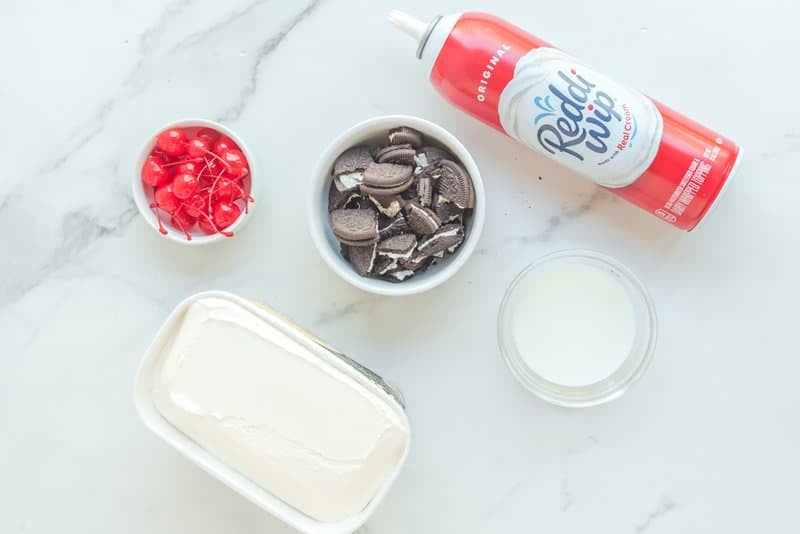 Copycat Chick Fil A cookies and cream milkshake ingredients on a marble surface.