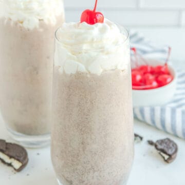 Copycat Chick Fil A cookies and cream milkshake, straws, Oreos, and cherries.