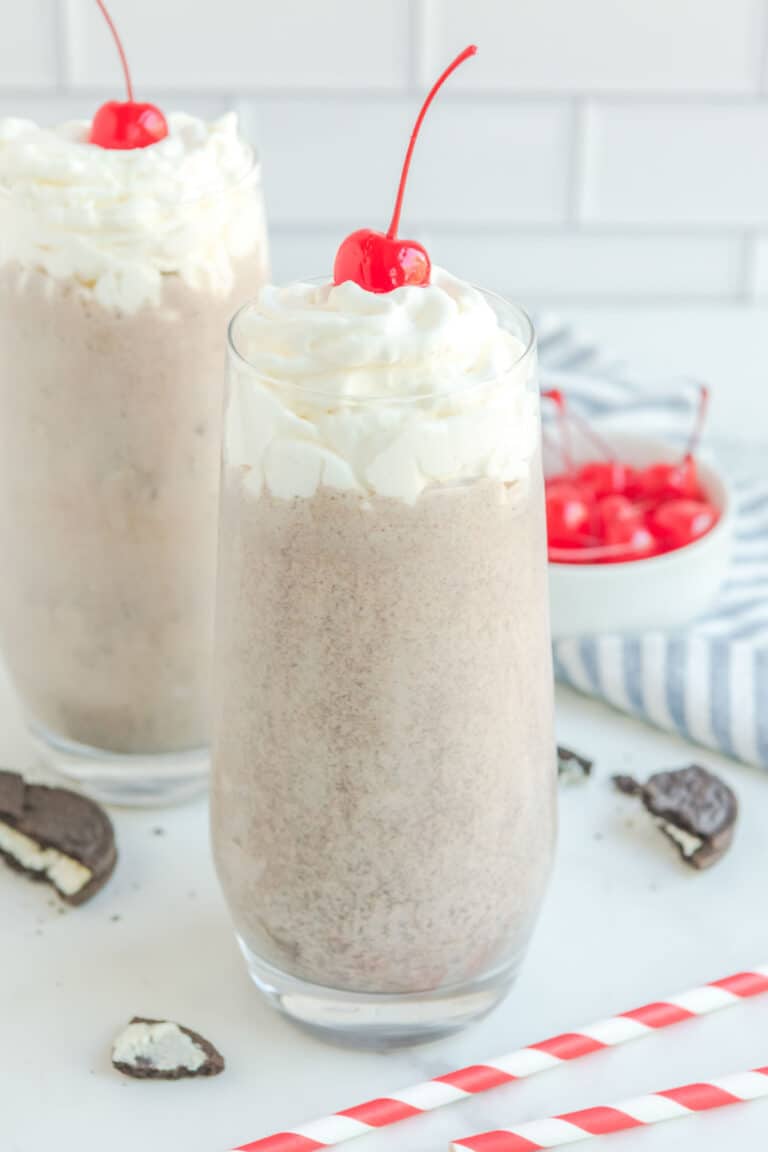 Copycat Chick Fil A cookies and cream milkshake, straws, Oreos, and cherries.