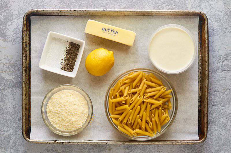 Greek pasta with lemon alfredo sauce ingredients on a tray.