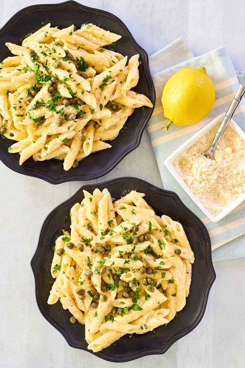 Overhead view of Greek pasta with lemon alfredo sauce on two plates.