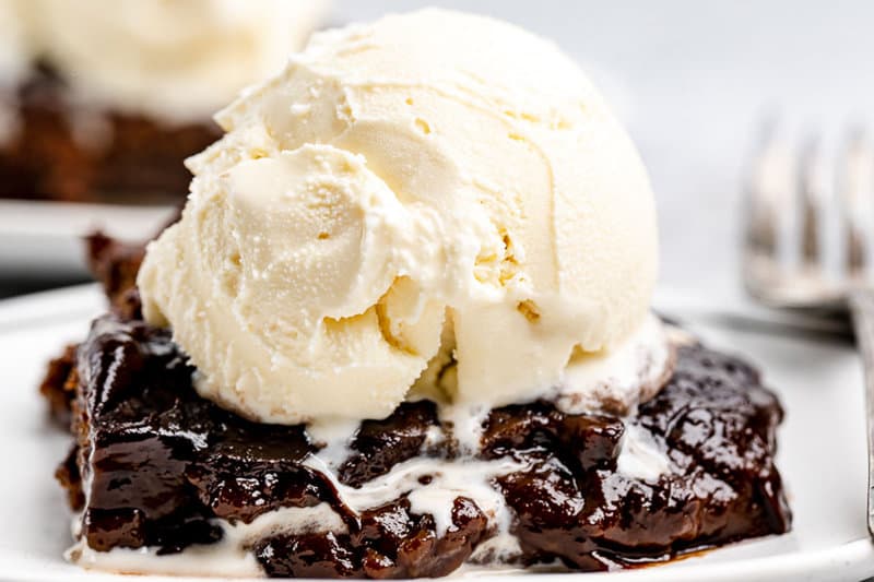 Hot fudge cake slice with ice cream on top.