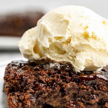 Slice of hot fudge cake topped with ice cream.