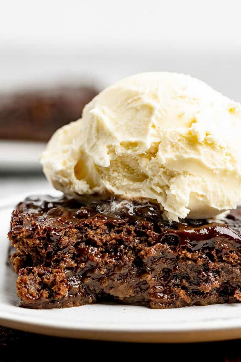 Slice of hot fudge cake topped with ice cream.