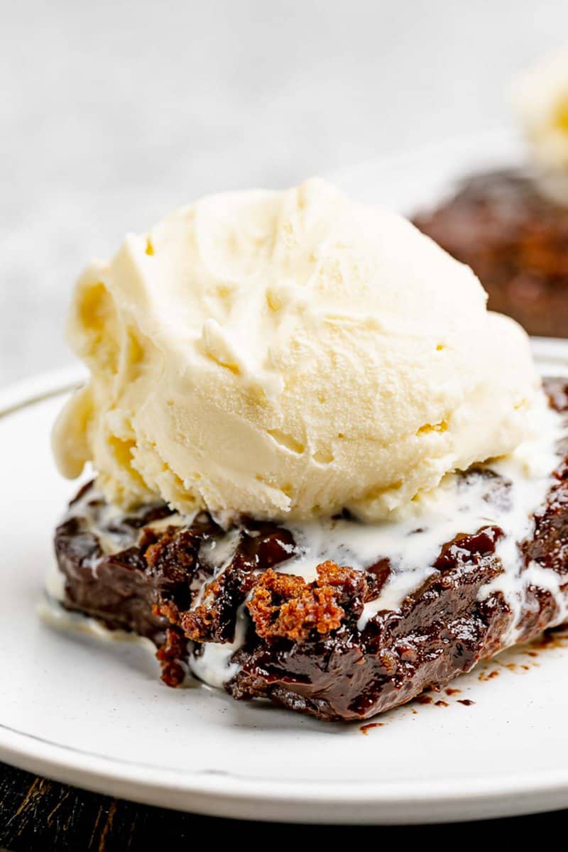 Hot fudge cake slice topped with ice cream.