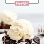 Hot fudge cake topped with vanilla ice cream on a white plate.
