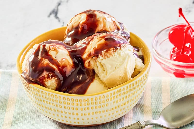 A bowl of vanilla ice cream topped with homemade hot fudge sauce.