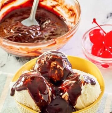 Homemade hot fudge sauce in a glass bowl and on top of ice cream.