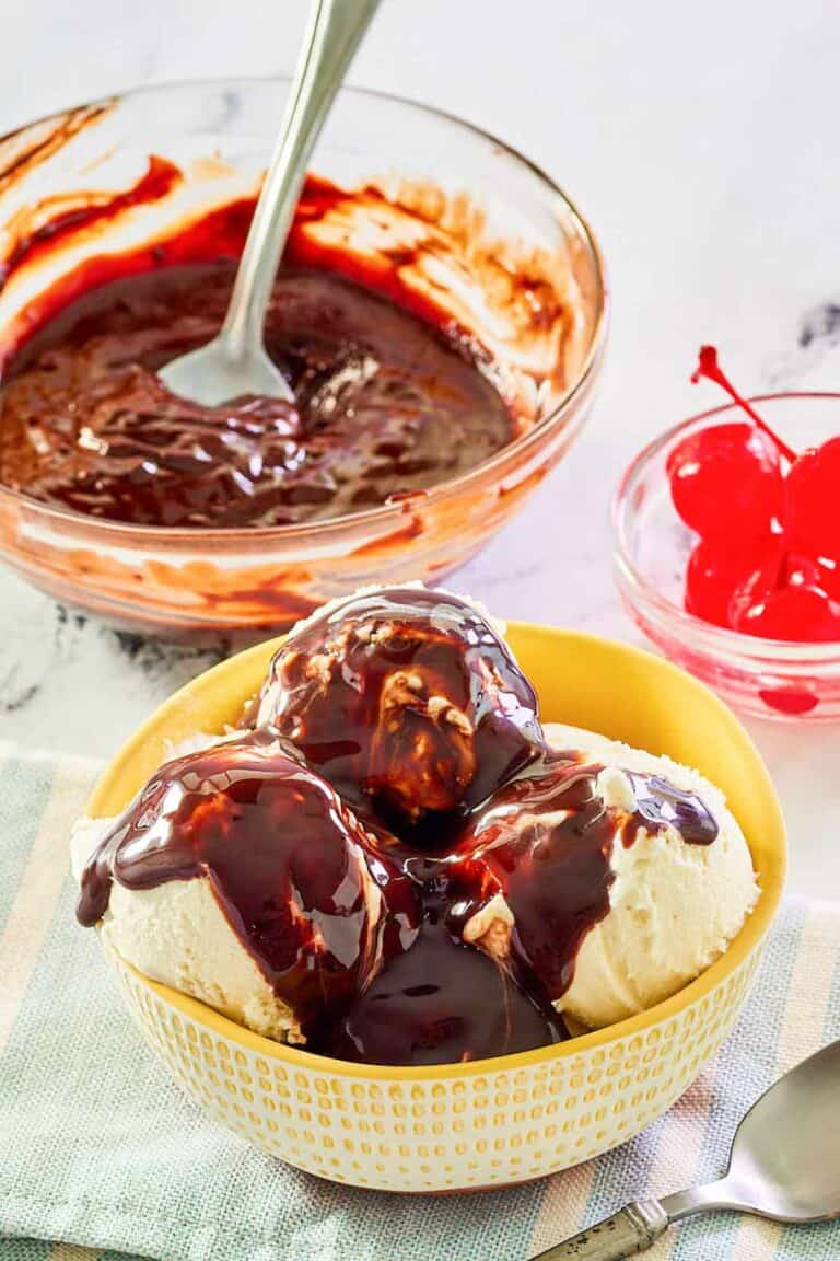 Homemade hot fudge sauce in a glass bowl and on top of ice cream.