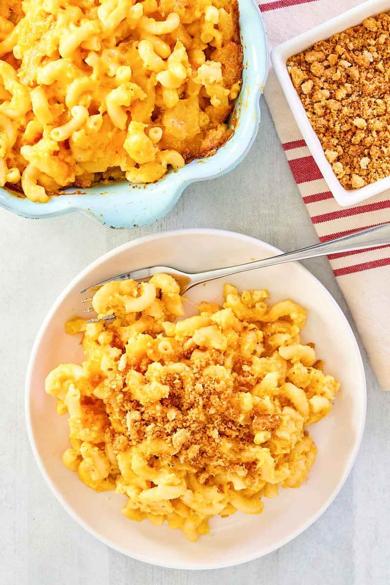 Overhead view of mac and cheese with bread crumbs on a plate and in a baking dish.