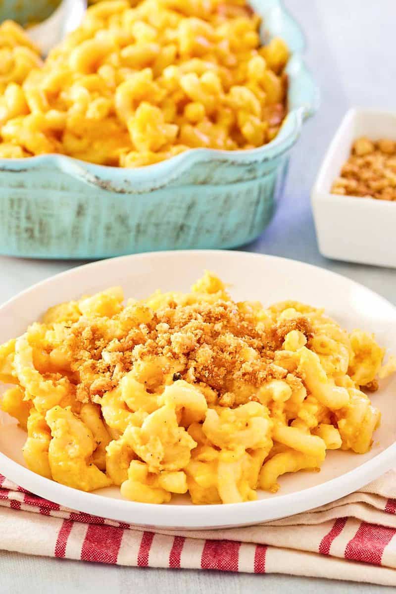 Homemade mac and cheese with bread crumbs in a baking dish and on a plate.