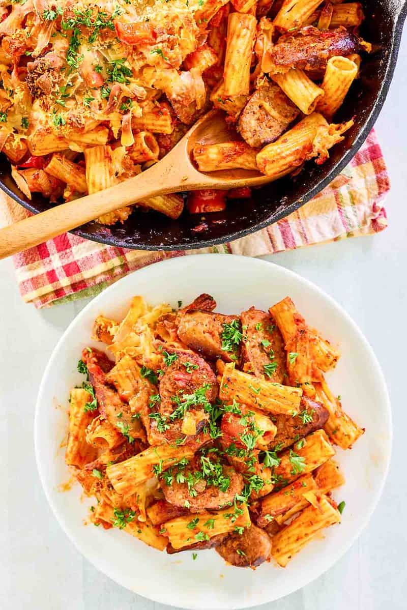 Overhead view of one pot sausage pasta in a skillet and on a plate.