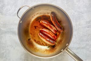 Cooking Italian sausages in a pan.