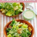Copycat Outback Caesar dressing in a small bowl next to two Caesar salads.