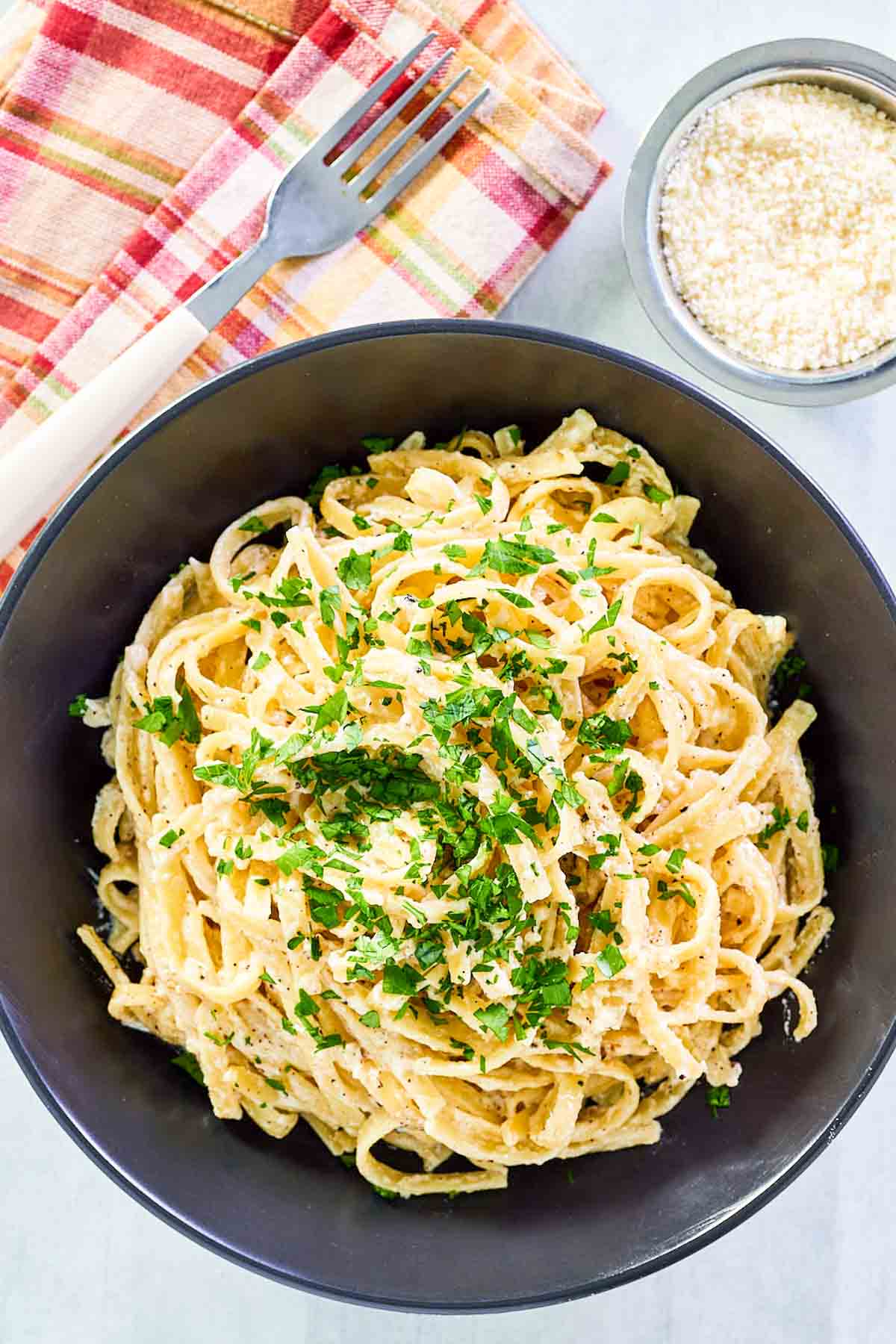 Overhead presumption    of copycat Pasta House fettuccine alfredo and grated parmesan cheese.