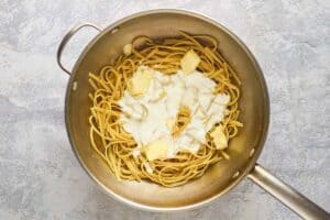 Fettuccine pasta, butter, and half-and-half in a pot.