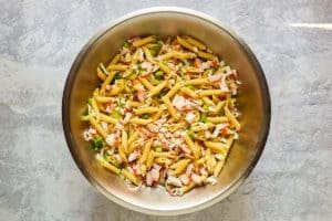 Seafood pasta salad ingredients in a large mixing bowl.