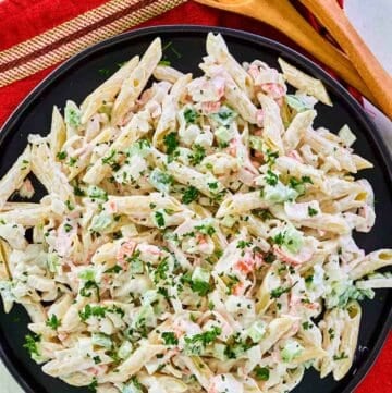 Overhead view of seafood pasta salad on a black plate.