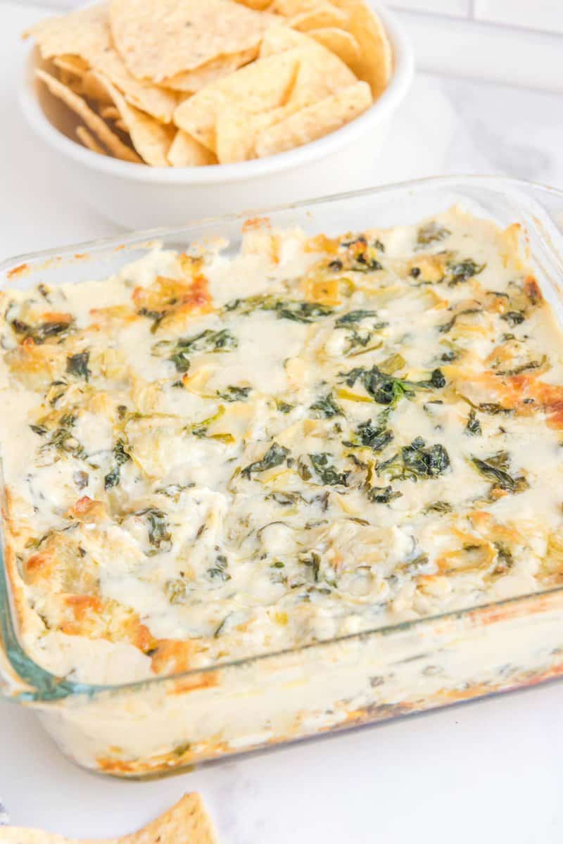 Copycat Applebee's spinach artichoke dip and a vessel  of tortilla chips.