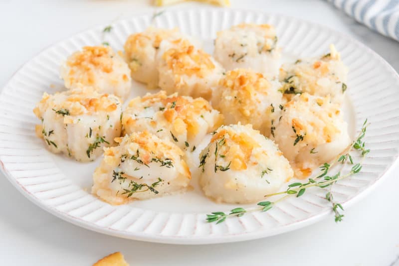 A plate of baked sea scallops with Ritz cracker topping.