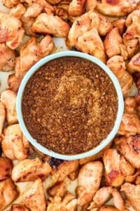 Overhead view of copycat Benihana ginger sauce in a bowl with cooked chicken pieces around it.