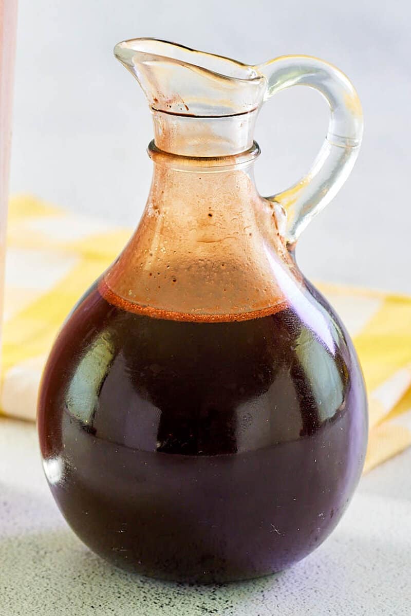 Homemade chocolate syrup in a glass pitcher.