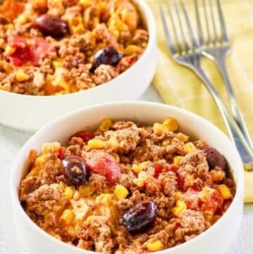 Two servings of hamburger corn casserole in white bowls.