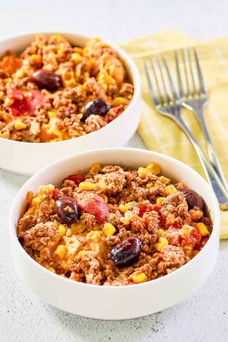 Two servings of hamburger corn casserole in white bowls.
