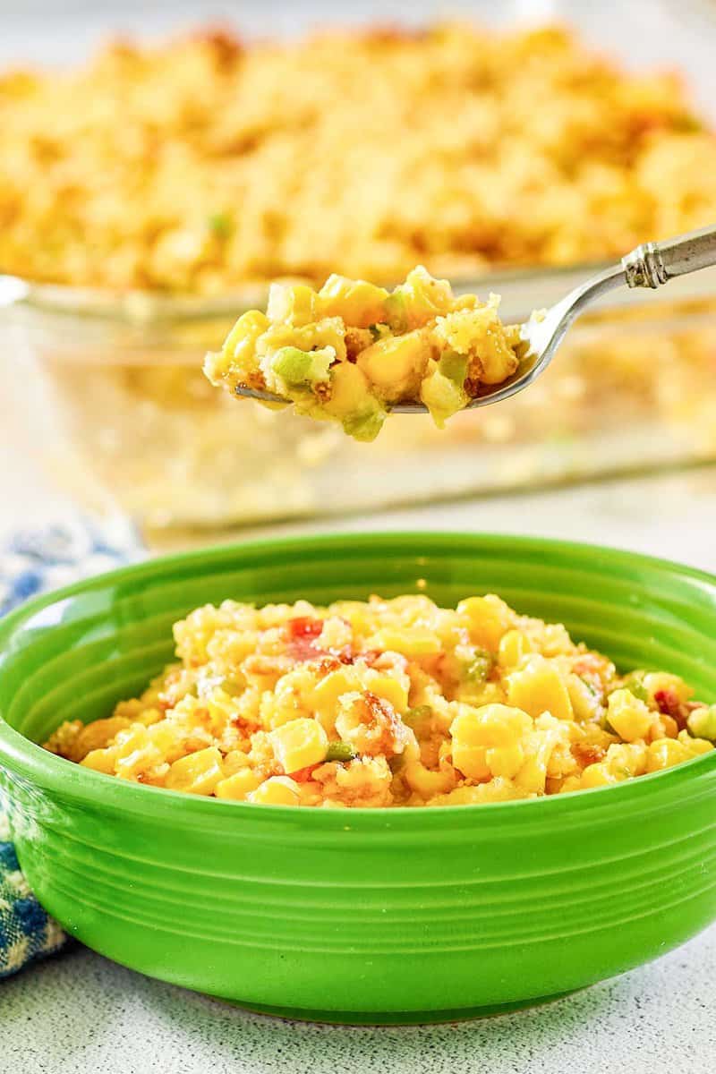 Copycat Luby's Spanish Indian baked corn casserole on a fork over a bowl of it.