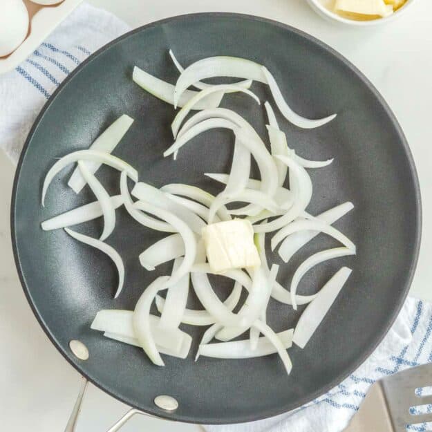 Sliced onions and butter in a skillet.
