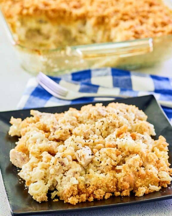 Ritz cracker chicken casserole in a glass baking dish and a serving on a plate.