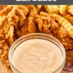 Homemade Zaxby's Zax sauce in a small bowl on a wood board with chicken and fries.