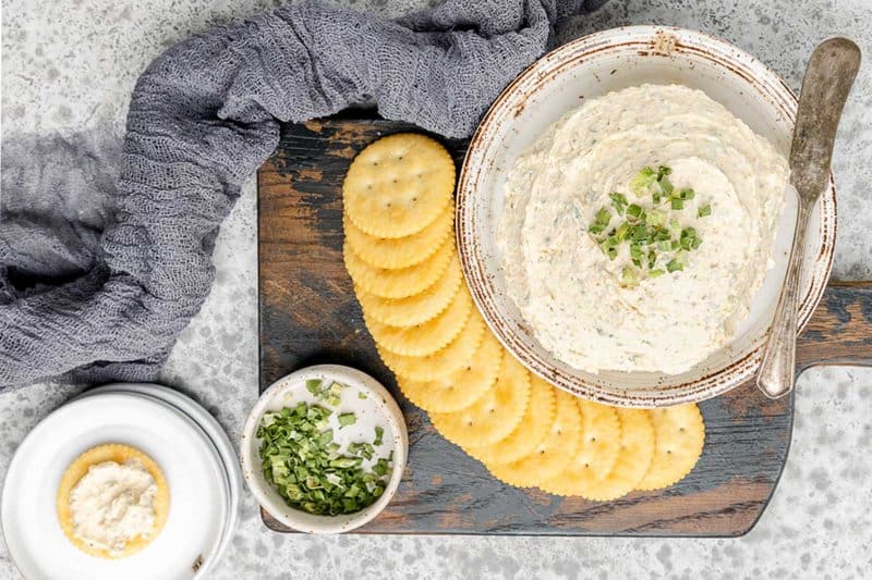 Overhead view of homemade boursin cheese on a plate and butter crackers next to it.