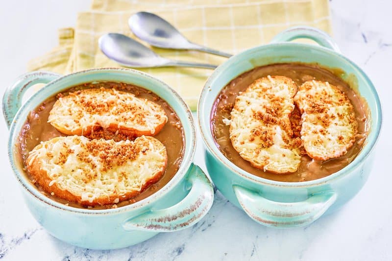 Copycat Brennan's French onion soup in two bowls and two spoons.