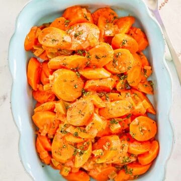 Overhead view of copper penny carrots in a serving dish.