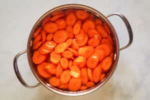 Sliced carrots and water in a pan.