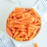 Overhead view of copycat Cracker Barrel baby carrots and a small bowl of ground nutmeg.