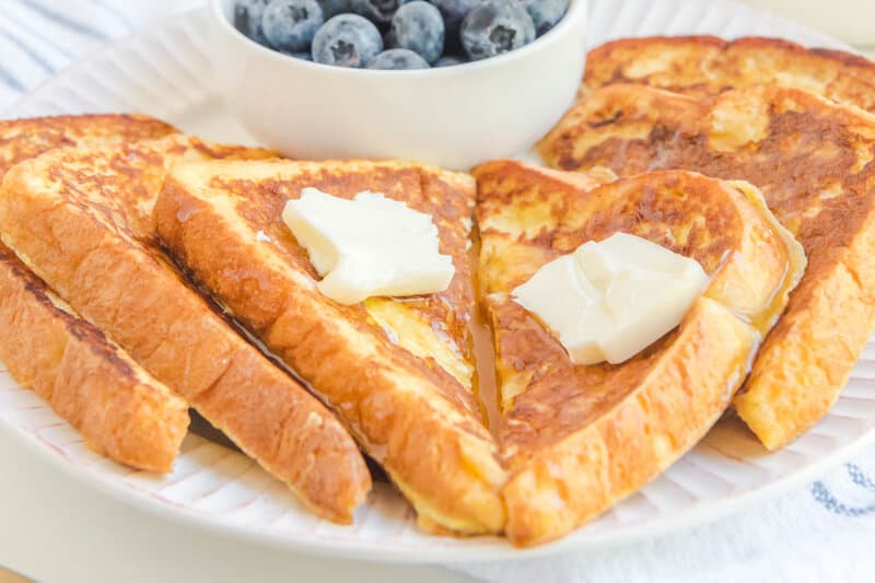 Closeup of copycat Cracker Barrel French toast with butter and syrup on a plate.