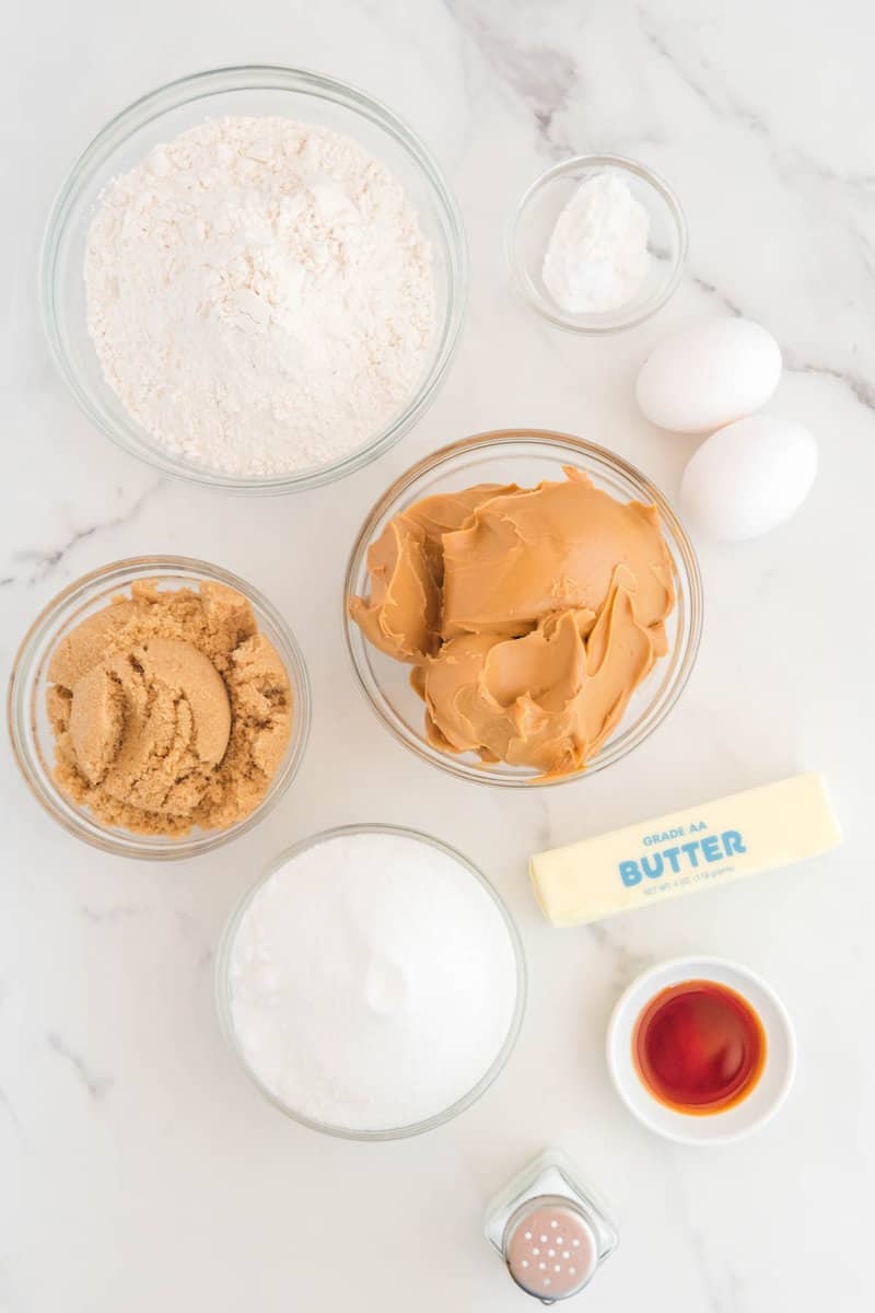 Copycat Crumbl ultimate peanut butter cookies ingredients on a marble surface.