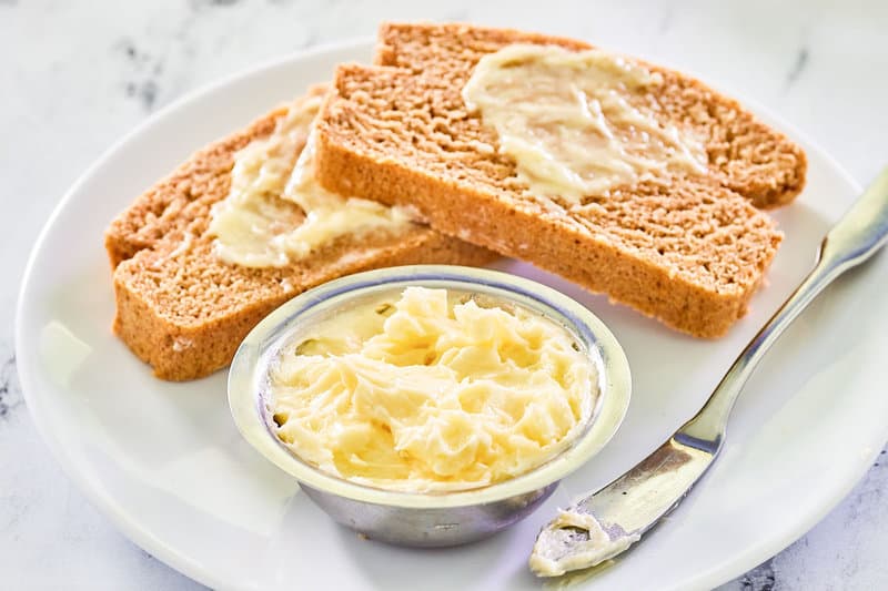 Copycat Saltgrass Steakhouse honey butter on a plate with bread slices.