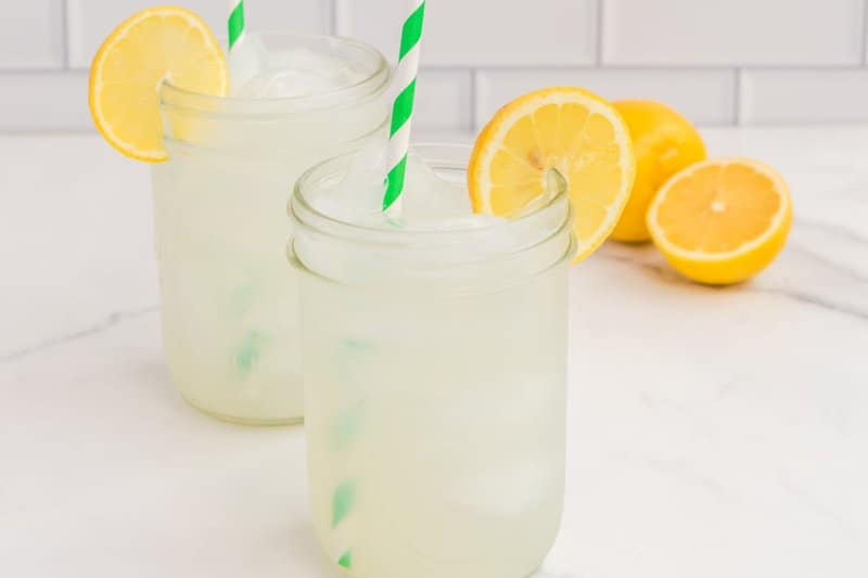 Copycat Starbucks lemonade in two mason jars garnished with lemon slices.
