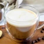 Homemade Starbucks oleato caffe latte in a mug on a wood board.