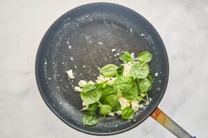 Cooked egg whites and spinach in a skillet.