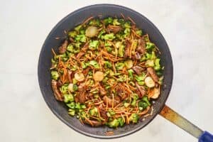 Beef strips and stir fry vegetables in a skillet.