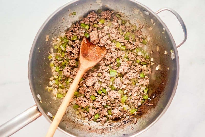 Cooked ground beef, onions, and bell peppers in a skillet.